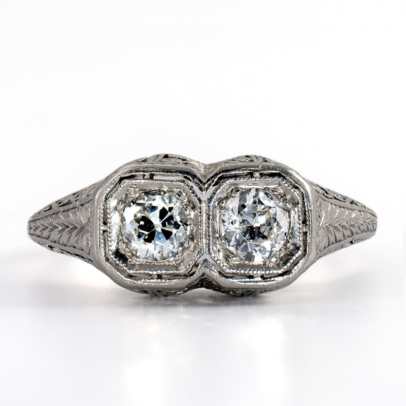 straight on view of an Art Deco two-stone platinum ring with matched Old European diamonds framed by crisp milgrained borders.