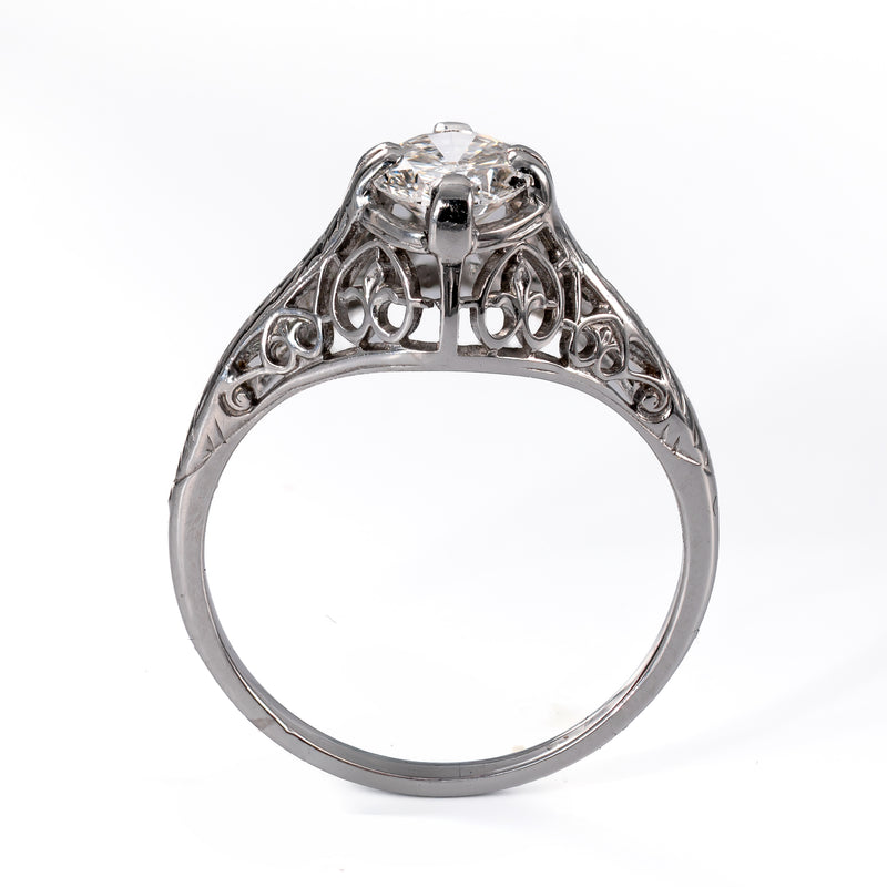 Profile view of an early Art Deco 18K white gold engagement ring showing scrolling heart openwork gallery