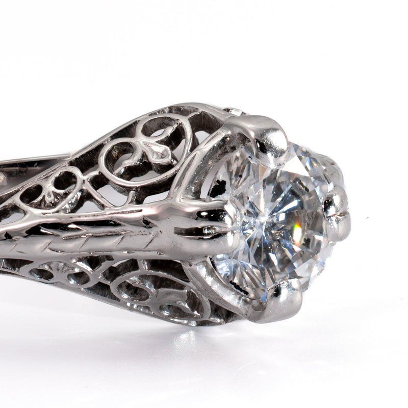 Side view showing engraved wheat-pattern shoulders and four-prong head on an Art Deco filigree ring
