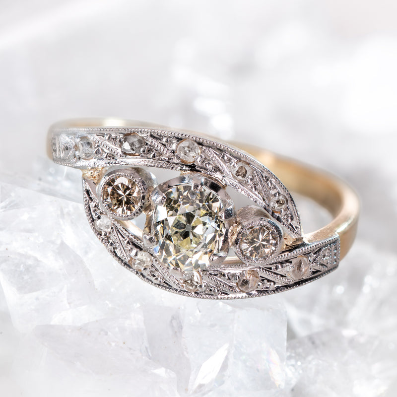 Edwardian ring with art nouveau influence featuring a center old mone cut, two transitional cut and ten rose cut diamonds.