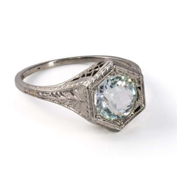Detailed angle of the hand-engraved wheat and foliate patterns along the shoulder of an 18K white gold Belais ring.