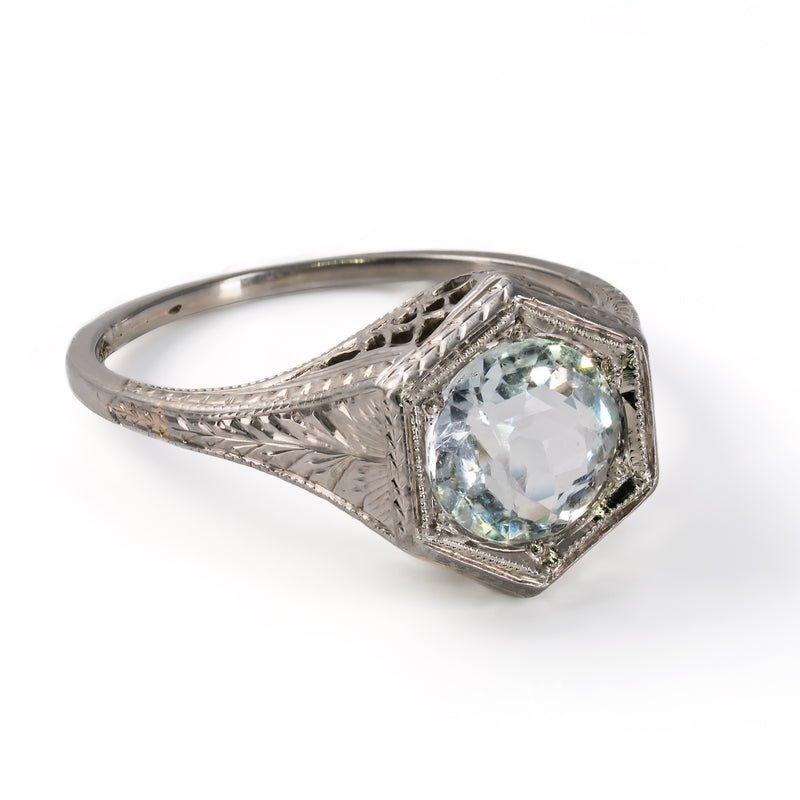 Detailed angle of the hand-engraved wheat and foliate patterns along the shoulder of an 18K white gold Belais ring.