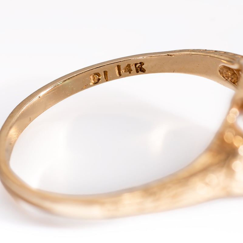 Macro close-up of the maker's hallmark and 14K gold purity stamp stamped inside the interior ring shank.