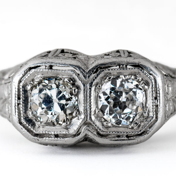 Macro shot of two matched Old European cut diamonds set in geometric, milgrained octagonal platinum bezels showing cut facets and open culets.