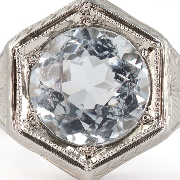 Extreme macro top view of a period-correct native-cut 1.30-carat round aquamarine showing cutting facets and icy blue color.