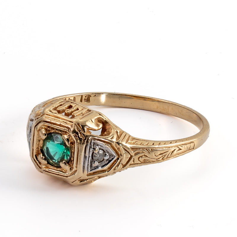 Angled side view showing the intricate floral and scroll hand engraving on the 14K yellow gold shank and side accent diamond.