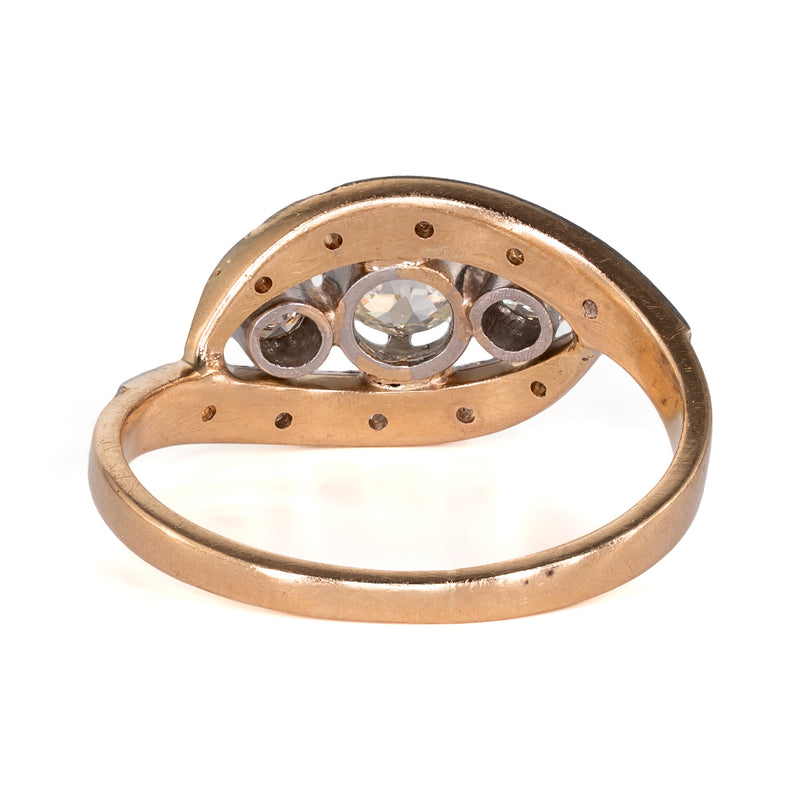 Underside view of the ring displaying the smooth 18k yellow-gold band, pierced open-back diamond gallery, and under-bezel construction.