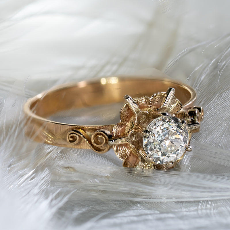 Vintage late Art Deco 0.45ct Old European Cut diamond floral buttercup ring in 14K yellow gold resting on feathers