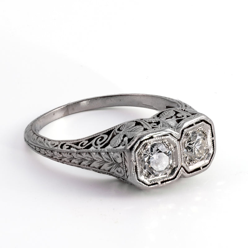 Side profile view of a bespoke 1920s platinum ring showcasing hand-engraved wheat leaf patterns along the band and a hand-pierced under-gallery.